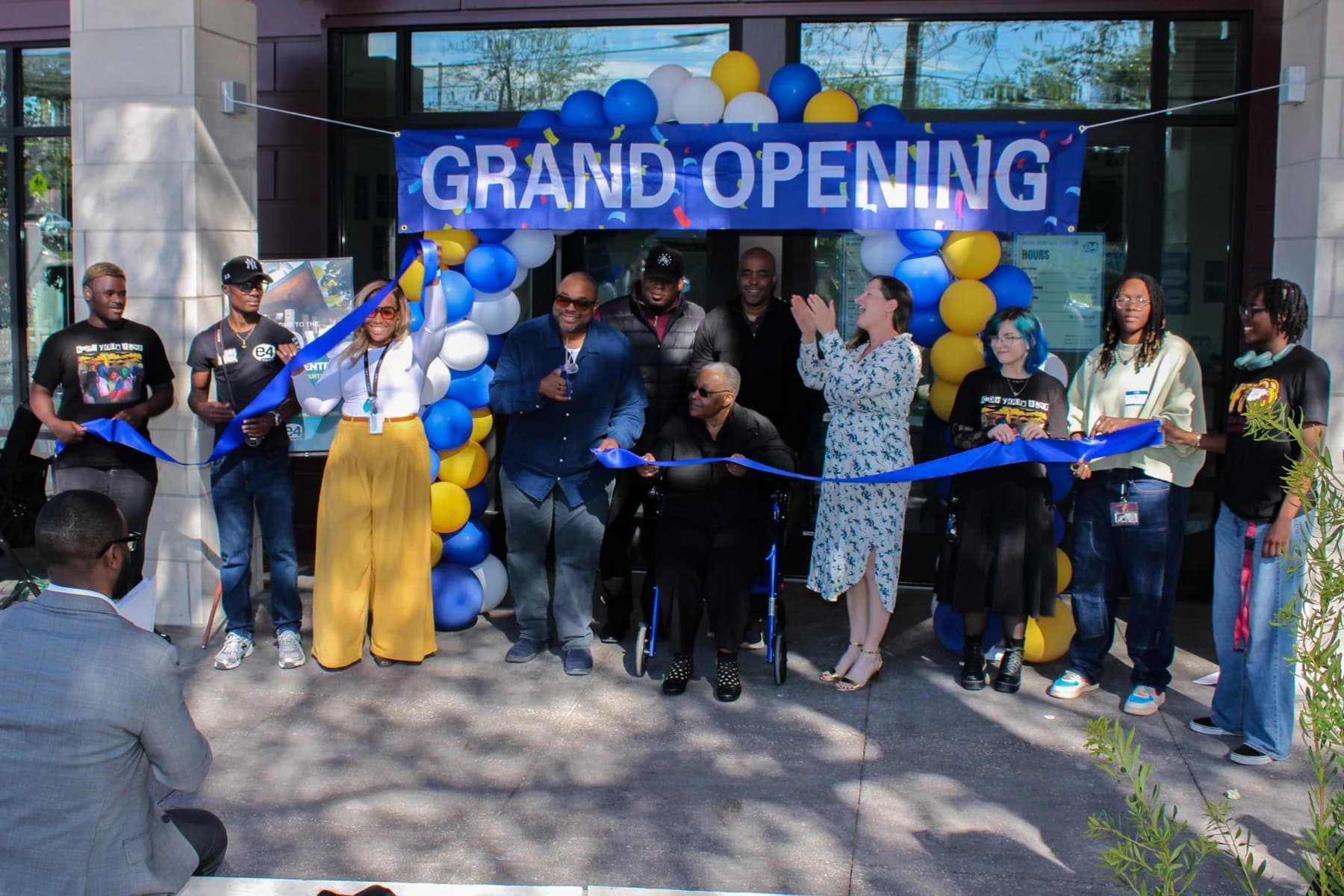 Community members gather beneath a Grand Opening banner for the WOW Heritage Center ribbon-cutting ceremony.