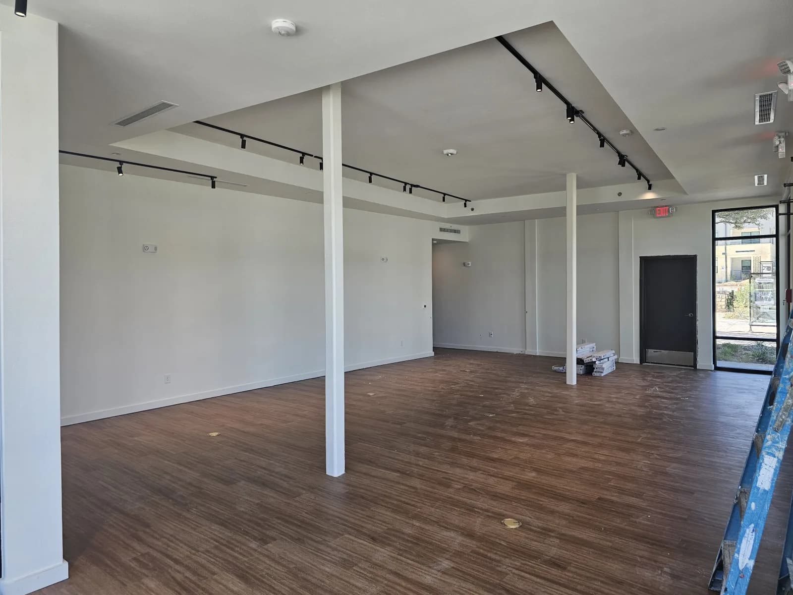 The interior of the WOW Heritage Center during setup, track lighting installed and flooring materials still stacked on the floor.